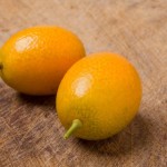 Two kumquats on old table.
